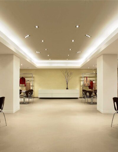 Modern boutique interior with clothing racks and seating area.